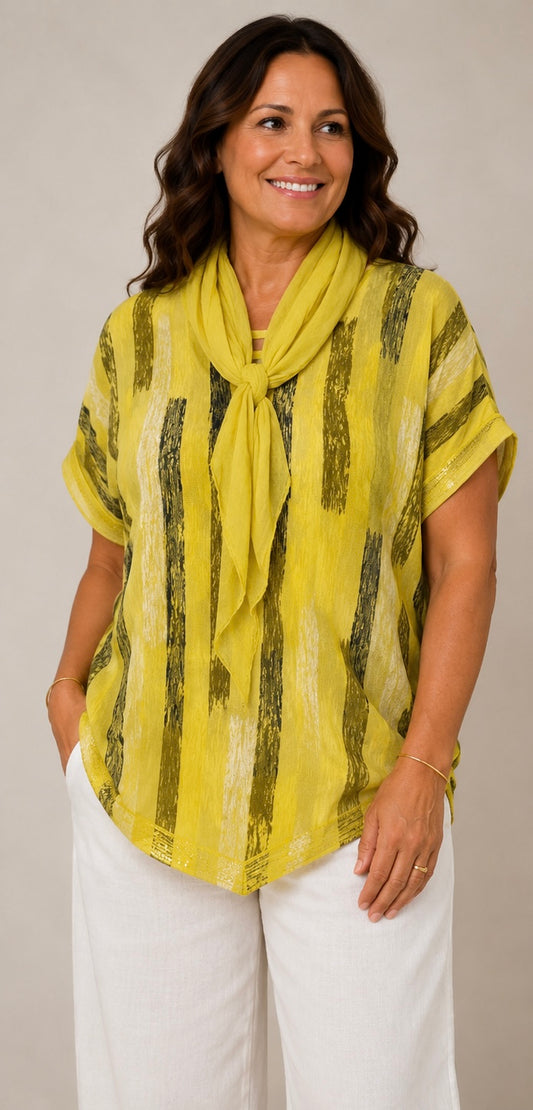 A woman modeling a yellow short-sleeve top with vertical black textured stripes and a matching yellow scarf, paired with white pants, against a plain light gray background.